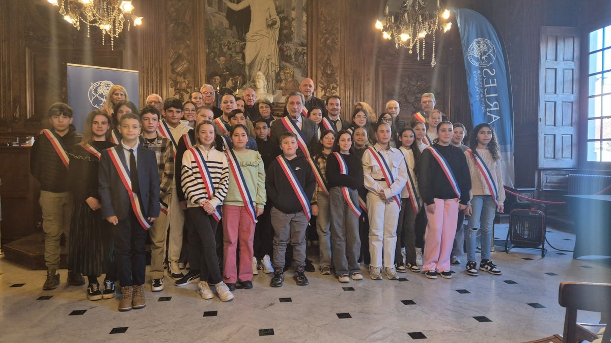 Le conseil municipal des jeunes pose aux côtés d'élus municipaux à Arles.