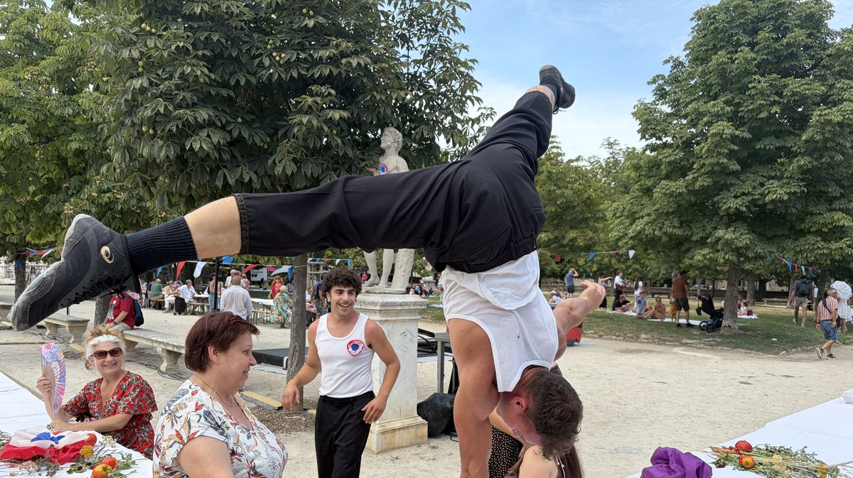 Un acrobate, lui aussi, s’installe à la table de Marianne… Mais carrément sur une table, tête en bas !