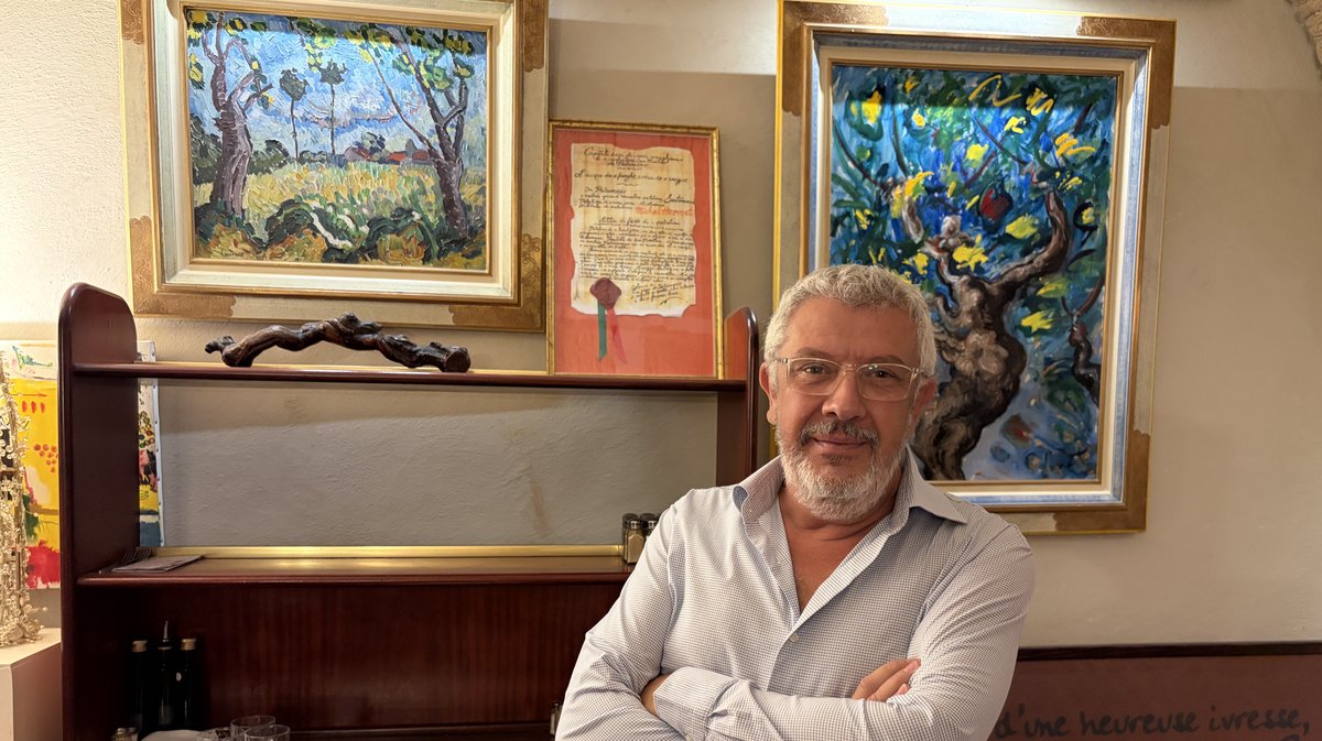Mathieu Laurent devant les tableaux de son père, exposés au Cheval Blanc